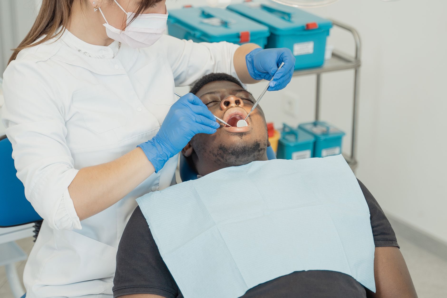 Dentist providing prompt urgent care to a patient in a treatment chair